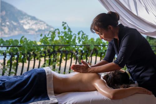 a woman is giving a woman a back massage at Hotel Le Agavi in Positano