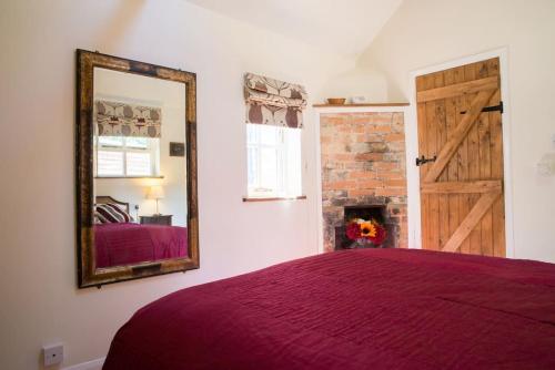 a bedroom with a bed and a mirror at The Doghouse near Silverstone in Buckingham