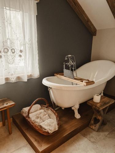 a bathroom with a white bath tub and a basket at Evas Boutique Alm in Kloster
