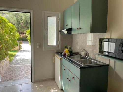 a kitchen with a sink and a microwave at Stefanos Home in Katelios