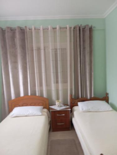 two beds in a small room with curtains at Chrisa apartament in Metogjashta