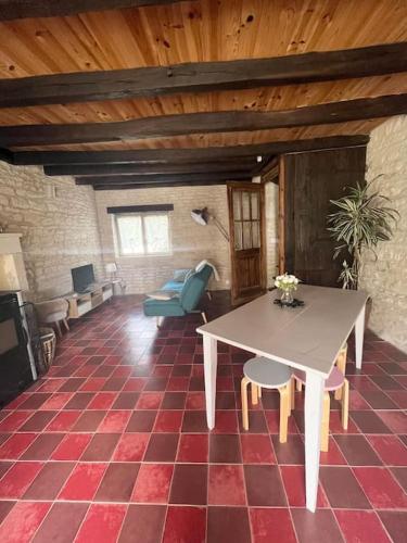 un salon avec une table et des chaises dans un immeuble dans l'établissement Charmante maisonnette proche Futuroscope, à Neuville-du-Poitou