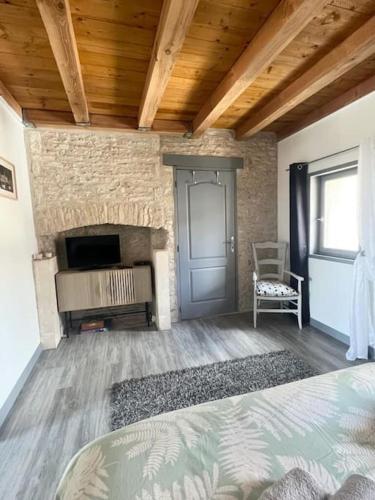 - une chambre avec une cheminée et un lit dans une pièce dans l'établissement Charmante maisonnette proche Futuroscope, à Neuville-du-Poitou