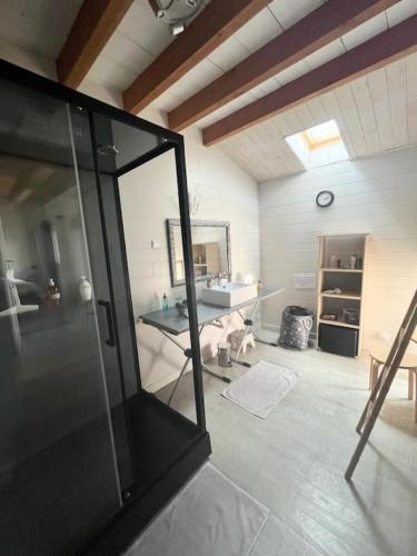 La grande salle de bains est pourvue d'un lavabo et d'une table. dans l'établissement Charmante maisonnette proche Futuroscope, à Neuville-du-Poitou