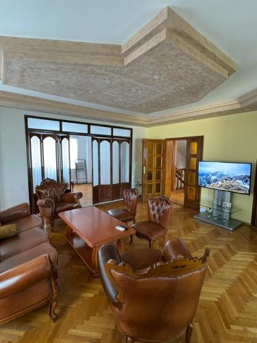a living room with a table and chairs and a tv at Vila Andrijana in Bijeljina