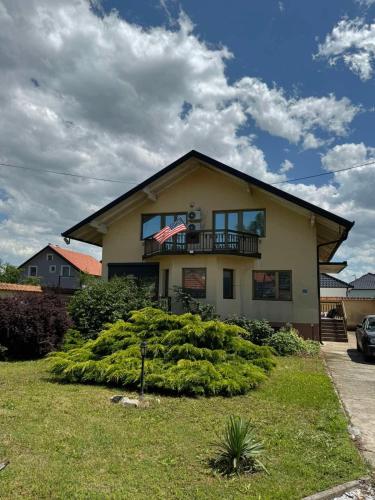 a house with a balcony on top of it at Vila Andrijana in Bijeljina