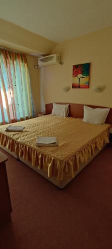 a bedroom with a large bed in a room at Family Hotel Mimosa in Tsarevo