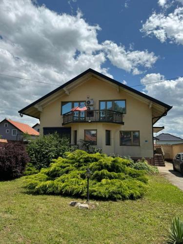 a house with a balcony on top of a bush at Vila Andrijana in Bijeljina