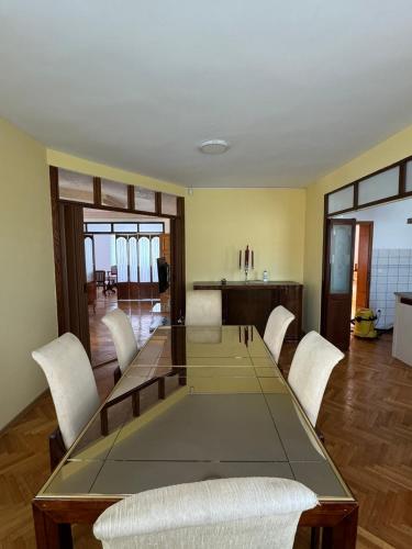 a dining room with a glass table and white chairs at Vila Andrijana in Bijeljina