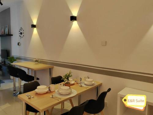 un comedor con 2 mesas, sillas y luces en Anderson, Ipoh at E&R Suite, en Kampong Simee