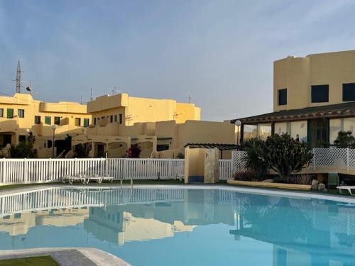 a large swimming pool in front of some buildings at Villa Los Silos in Costa Calma