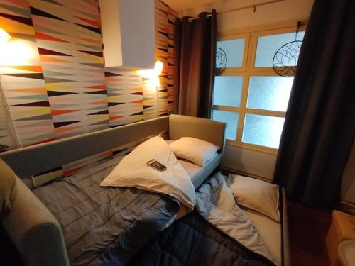 un petit lit dans une chambre avec une fenêtre dans l'établissement Appartement plein centre avec terrasse, à Lons-le-Saunier