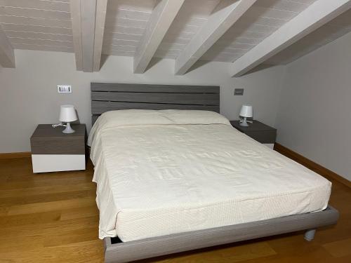 a bedroom with a large bed and two night stands at Appartamento Scoggione in Colico