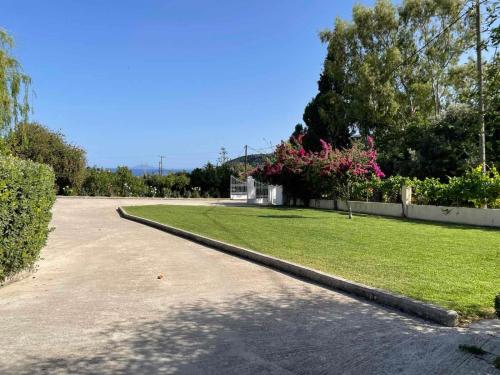 a driveway with a yard with grass and trees at Stefanos Home in Katelios