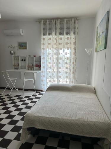 a bedroom with a bed and a checkered floor at Casa Sweet-lama in Calatabiano