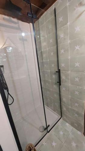 a shower with a glass door with stars on the wall at El Cuadro de Llanes in Vibaño