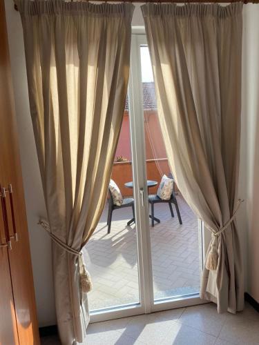a sliding glass door with curtains in a room at Green Quiet Affittacamere in Pignone