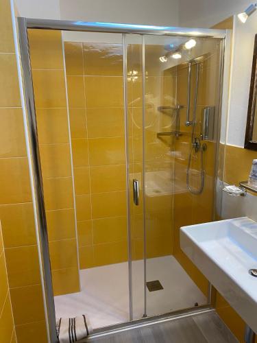 a shower with a glass door next to a sink at Green Quiet Affittacamere in Pignone