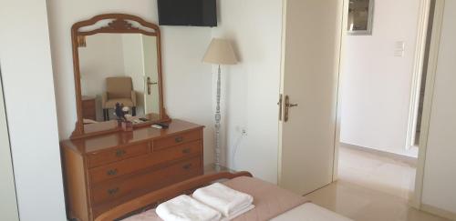 a bedroom with a mirror and a dresser with towels at Vaso Studios in Vathi, Ithaka
