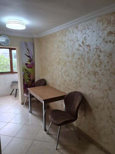 Un comedor con una mesa de madera y dos sillas. en Atlas Unirii, en Buzau