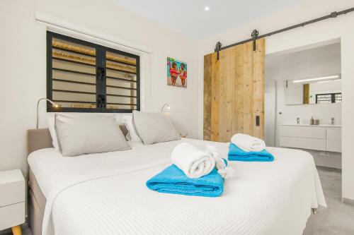 una camera da letto con due letti con asciugamani sopra di Villa Dushi Mambo a Willemstad