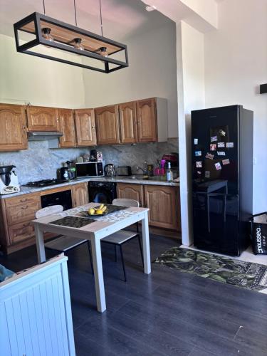 Il comprend une cuisine équipée d'une table blanche et d'un réfrigérateur noir. dans l'établissement Appartement de caractère superficie 50 m2, à Corte