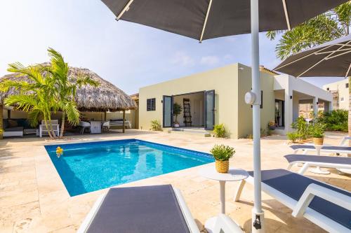 una villa con piscina e ombrellone di Villa Dushi Mambo a Willemstad
