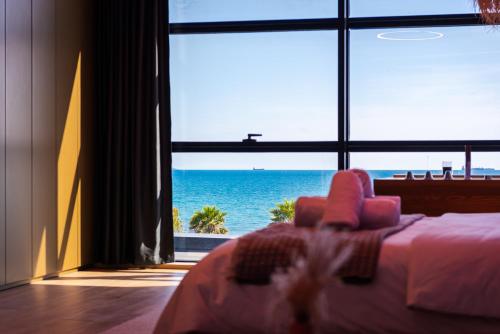a bedroom with a bed and a view of the ocean at Marina Luxury Suites by PS in Durrës