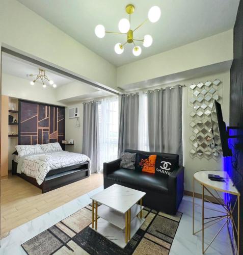 un salon avec un lit et un canapé dans l'établissement Executive Studio Palladium, à Iloilo