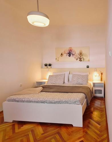 a bedroom with a large white bed in a room at Vlatkovićeva Apartments in Senj