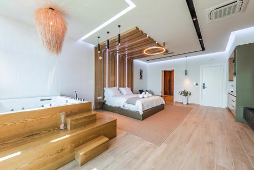 a bedroom with a bed and a bath tub in it at Marina Luxury Suites by PS in Durrës