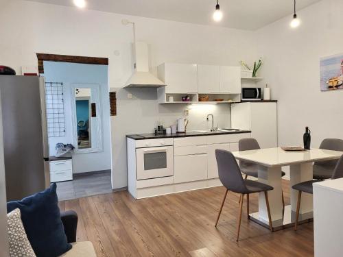 a kitchen with white cabinets and a table and chairs at Holiday home Blue door in Pula in Pula