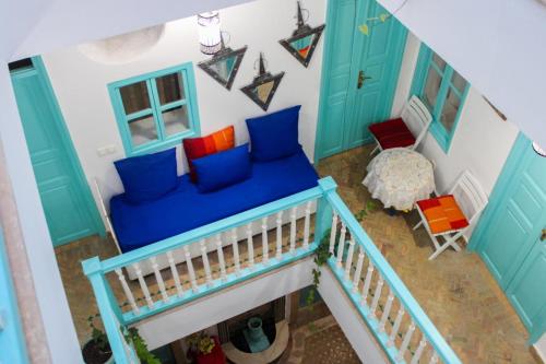 uma vista superior de uma sala de estar com um sofá azul em Riad Darko em Essaouira