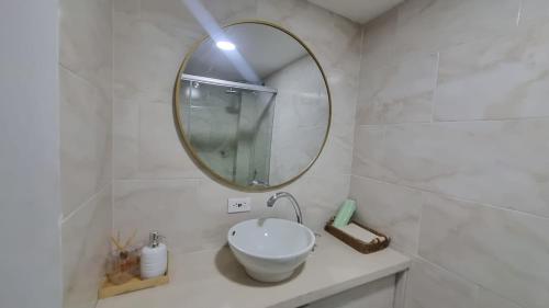 a white bathroom with a mirror and a sink at Apartamento de descanso Om Shanti Om in Coveñas