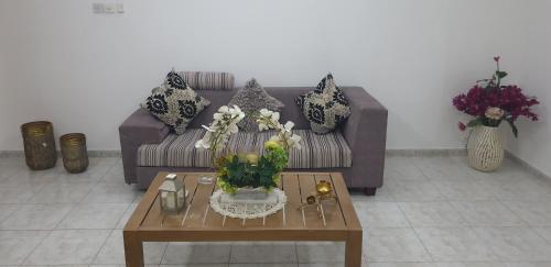 a living room with a couch and a table with flowers at HOUSE IN AL AIN - 4 in Al Ain
