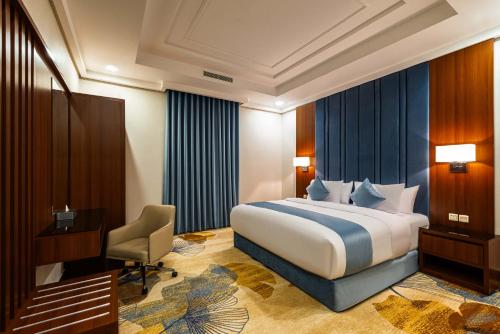 a bedroom with a bed and a desk and a chair at Yas Hotel Apartments in Riyadh
