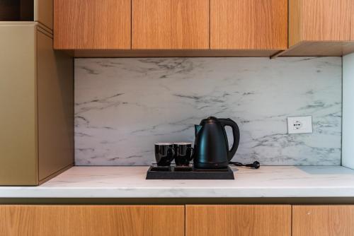 a black tea kettle on a counter in a kitchen at Marina Luxury Suites by PS in Durrës