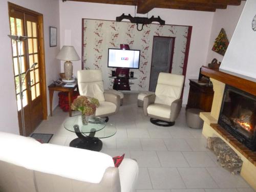a living room with white furniture and a fireplace at Maison de Vacances MACOU 2 in Capdrot