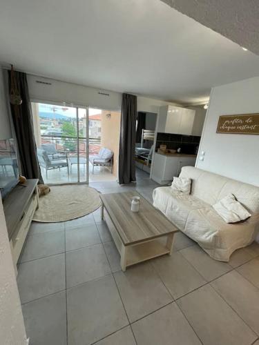 un salon avec un canapé et une table dans l'établissement T2 lumineux Mer à pied Terrasse Piscine, à Cannes