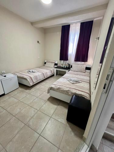 two beds in a room with purple curtains at Lux Ohrid in Ohrid