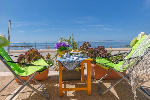 a table and two chairs and flowers on a balcony at Casa La Conchiglia in Sciacca