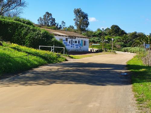 a dirt road with a house in the distance at Kingfisher by the river - self catering in Velddrif