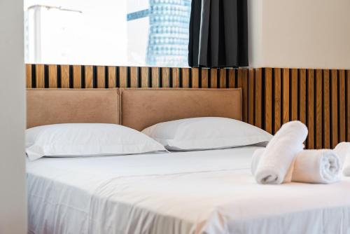 a bed with white sheets and towels on it at Marina Luxury Suites by PS in Durrës