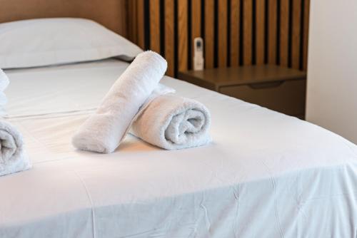 a bed with two rolled towels on top of it at Marina Luxury Suites by PS in Durrës