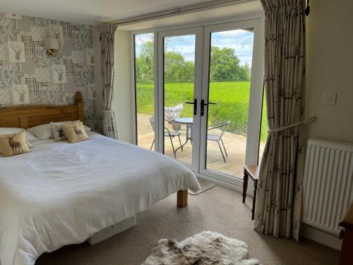 a bedroom with a bed and a sliding glass door at Picket Post House Bed & Breakfast in Catterall