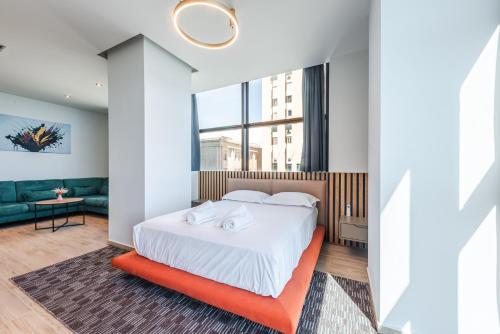 a bedroom with a bed and a couch at Marina Luxury Suites by PS in Durrës