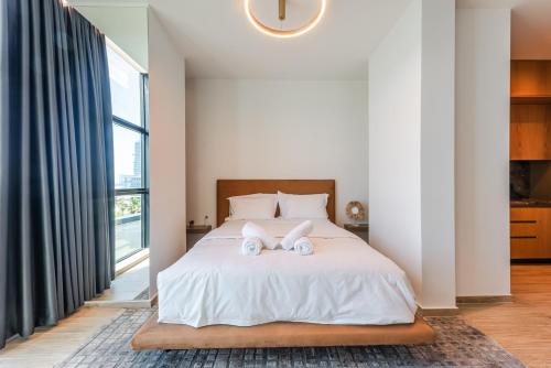 a bedroom with a bed with two towels on it at Marina Luxury Suites by PS in Durrës