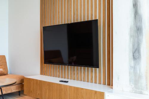 a flat screen tv on a wooden wall at Marina Luxury Suites by PS in Durrës