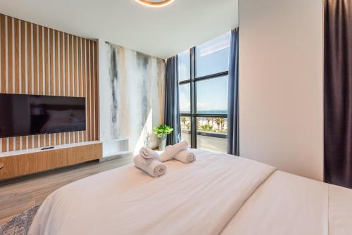 a bedroom with a large bed with towels on it at Marina Luxury Suites by PS in Durrës