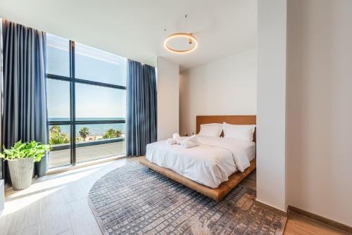a bedroom with a bed and a large window at Marina Luxury Suites by PS in Durrës